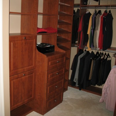 In this awesome closet, a deep drawer hutch is flanked by dual tilting hampers and an angled shoe display.